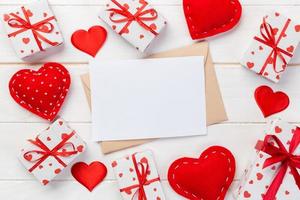 courrier enveloppe avec coeur rouge et boîte-cadeau sur fond de bois blanc. carte de saint valentin, concept de voeux d'amour ou de mariage photo