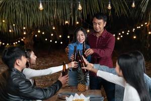 les jeunes couples et les amis profitent d'une joyeuse fête de vacances en buvant de la bière ensemble. photo