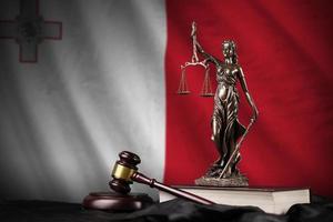 drapeau de malte avec statue de dame justice, constitution et juge marteau sur draperie noire. concept de jugement et de culpabilité photo