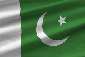 drapeau pakistanais avec de grands plis agitant de près sous la lumière du studio à l'intérieur. les symboles et couleurs officiels de la bannière photo