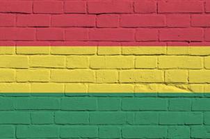 drapeau de la bolivie représenté dans des couleurs de peinture sur un vieux mur de briques. bannière texturée sur fond de maçonnerie de gros mur de briques photo