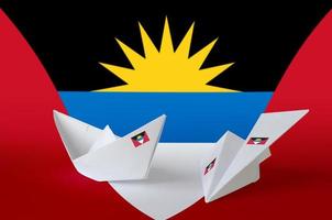 drapeau antigua-et-barbuda représenté sur un avion et un bateau en papier origami. concept d'art fait à la main photo