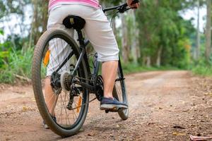 femme d'affaires senior, femme, balade à vélo ou vélo de montagne dans un parc de campagne près de la ville natale pour un exercice sain le week-end d'été photo