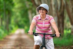 femme d'affaires senior, femme, balade à vélo ou vélo de montagne dans un parc de campagne près de la ville natale pour un exercice sain le week-end d'été photo