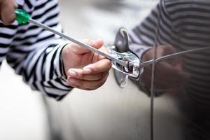 voleur de voiture détourner et voler ou voler de l'argent dans la voiture et la voiture casser la fenêtre de la porte sans alarme de voiture travail criminel illégal et violent photo