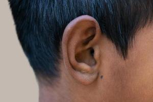 oreille humaine - gros plan sur l'oreille d'un homme, sa partie du corps aide à entendre les ondes sonores. photo