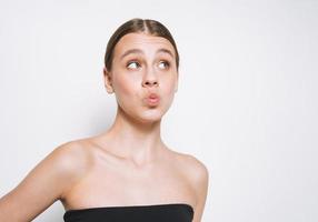 portrait de beauté d'une jeune fille drôle avec un teint frais montrant un baiser sur fond blanc isolé photo