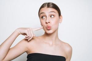 portrait de beauté d'une jeune fille drôle avec un teint frais montrant un baiser sur fond blanc isolé photo