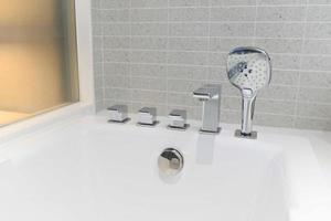 pommeau de douche et baignoire de robinet dans la salle de bains blanche photo