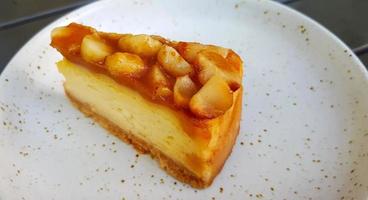 tranches de gâteau au fromage macadamia sur un plat blanc ou une assiette avec espace de copie à droite. dessert sucré et plats faits maison au café. photo