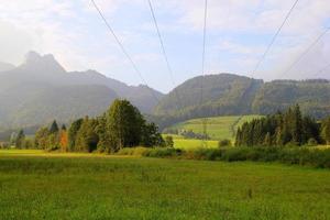 voyage à sankt-wolfgang, autriche. la vue sur le pré vert avec les montagnes en arrière-plan. photo