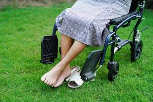 patient handicapé de femme âgée asiatique assis sur un fauteuil roulant dans le parc, concept médical. photo