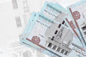 Les billets de 5 livres égyptiennes sont empilés sur fond de gros billets semi-transparents. présentation abstraite de la monnaie nationale photo