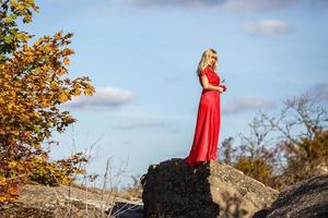 vue aérienne sur une fille en robe rouge sur un rocher ou une structure en béton en ruine photo