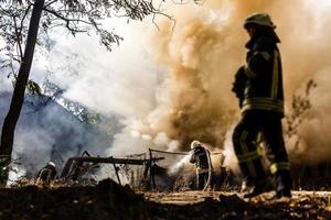 les pompiers éteignent un incendie dans la forêt par une inondation d'eau photo