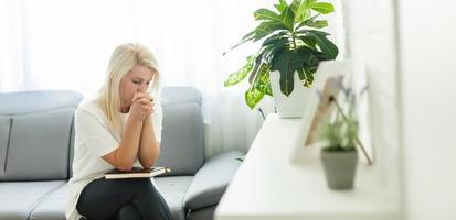 fidèle religieuse femme d'âge moyen priant avec espoir foi tenant les mains jointes à namaste à la maison le matin, vieille dame mûre croyante chrétienne disant la prière d'adoration les yeux fermés photo