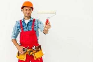 travaux de peinture de la chambre. Peintre avec un rouleau à peinture sur fond blanc photo