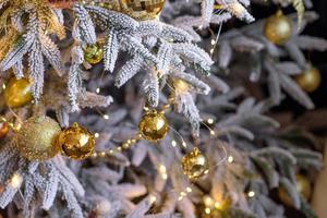 beau sapin de noël avec guirlandes, boules et jouets photo