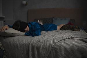 femme dormant dans son lit avec deux chats photo