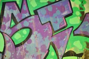 le vieux mur, peint en graffiti de couleur dessinant des peintures aérosols vertes. image de fond sur le thème du dessin graffiti et street art photo