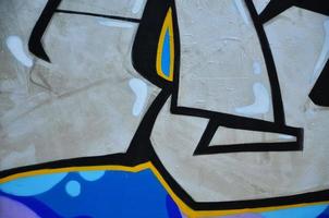 le vieux mur, peint en graffitis de couleur dessinant des peintures aérosols au chrome argenté. image de fond sur le thème du dessin graffiti et street art photo