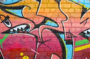 fragment coloré abstrait de peintures graffiti sur le vieux mur de briques. composition d'art de rue avec des parties de lettres non écrites et des taches multicolores. texture de fond sous-culturelle photo