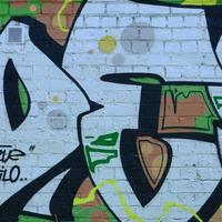 fragment de dessins de graffitis. le vieux mur décoré de taches de peinture dans le style de la culture de l'art de la rue. texture de fond colorée dans des tons verts photo