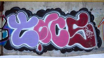 le vieux mur, peint en graffiti de couleur dessinant des peintures aérosols rouges. image de fond sur le thème du dessin graffiti et street art photo