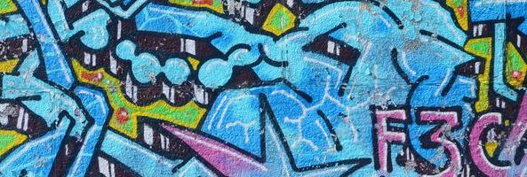 fragment de dessins de graffitis. le vieux mur décoré de taches de peinture dans le style de la culture de l'art de la rue. texture de fond colorée dans des tons froids photo