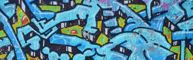 fragment de dessins de graffitis. le vieux mur décoré de taches de peinture dans le style de la culture de l'art de la rue. texture de fond colorée dans des tons froids photo