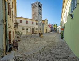 panorama sur la place centrale de motovun avec st. l'église de stephen et la porte de la ville au lever du soleil photo