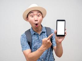 homme de tourisme étonné et pointant du doigt le téléphone portable pour réserver des vacances photo