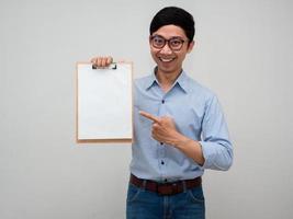 homme d'affaires positif porter des lunettes tenir le tableau de documents sourire joyeux pointer du doigt le tableau isolé photo