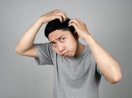 homme en gros plan trouvant des cheveux gris sur la tête se sent inquiet à propos de l'âge isolé photo