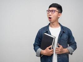 homme d'affaires positif porter des lunettes chemise jeans tenir le livre se sent étonné isolé photo