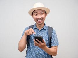 l'homme voyageur avec un doigt pointé sur un téléphone portable se sent heureux de vacances isolées photo