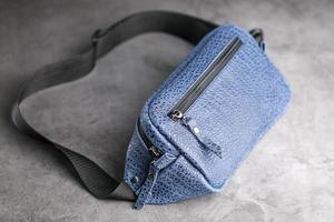 sac banane en cuir bleu, banane sur fond gris. photo