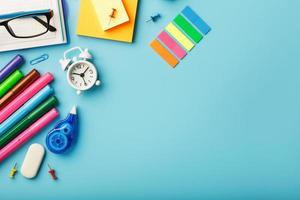 les fournitures de bureau se trouvent sur un fond bleu. étudier à l'école. couleur arc-en-ciel. photo