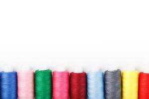 fils à coudre artisanaux en coton coloré multicolores d'affilée isolés sur fond blanc. photo