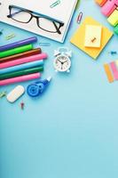 les fournitures de bureau se trouvent sur un fond bleu. étudier à l'école. couleur arc-en-ciel. photo