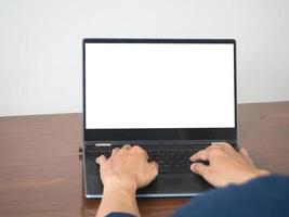 mains d'homme à l'aide du clavier d'un écran blanc de maquette d'ordinateur portable sur la table photo