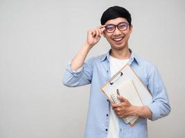 bel homme porter des lunettes sourire heureux tenant un livre de journal isolé photo