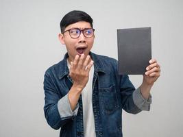 homme d'affaires positif porter des lunettes chemise jeans regardant le livre dans sa main se sent étonné isolé photo