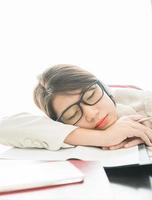 Adolescente cheveux courts dormir sur le bureau après avoir travaillé photo