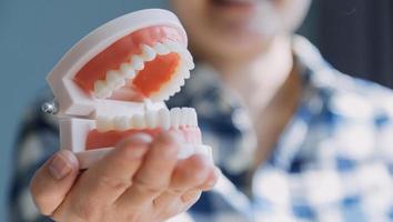 concept de stomatologie, portrait partiel d'une fille avec de fortes dents blanches regardant la caméra et souriant, les doigts près du visage. gros plan sur une jeune femme chez le dentiste, en studio, à l'intérieur photo