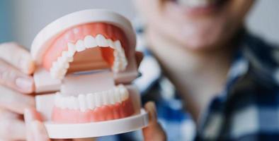 concept de stomatologie, portrait partiel d'une fille avec de fortes dents blanches regardant la caméra et souriant, les doigts près du visage. gros plan sur une jeune femme chez le dentiste, en studio, à l'intérieur photo