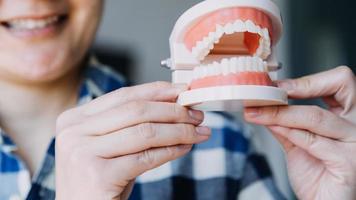 concept de stomatologie, portrait partiel d'une fille avec de fortes dents blanches regardant la caméra et souriant, les doigts près du visage. gros plan sur une jeune femme chez le dentiste, en studio, à l'intérieur photo