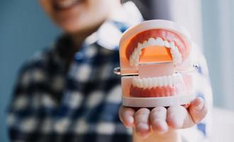 concept de stomatologie, portrait partiel d'une fille avec de fortes dents blanches regardant la caméra et souriant, les doigts près du visage. gros plan sur une jeune femme chez le dentiste, en studio, à l'intérieur photo