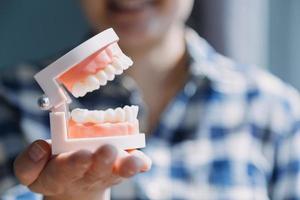 concept de stomatologie, portrait partiel d'une fille avec de fortes dents blanches regardant la caméra et souriant, les doigts près du visage. gros plan sur une jeune femme chez le dentiste, en studio, à l'intérieur photo