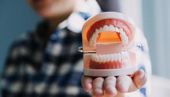 concept de stomatologie, portrait partiel d'une fille avec de fortes dents blanches regardant la caméra et souriant, les doigts près du visage. gros plan sur une jeune femme chez le dentiste, en studio, à l'intérieur photo